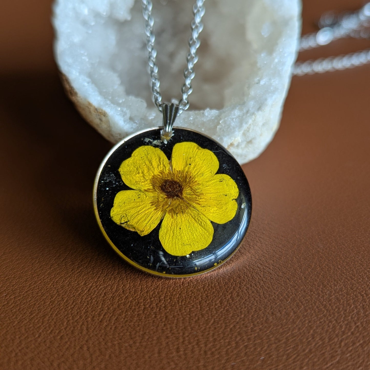 collier argenté avec bouton d'or jaune vif fleur séchée naturelle sur fond noir