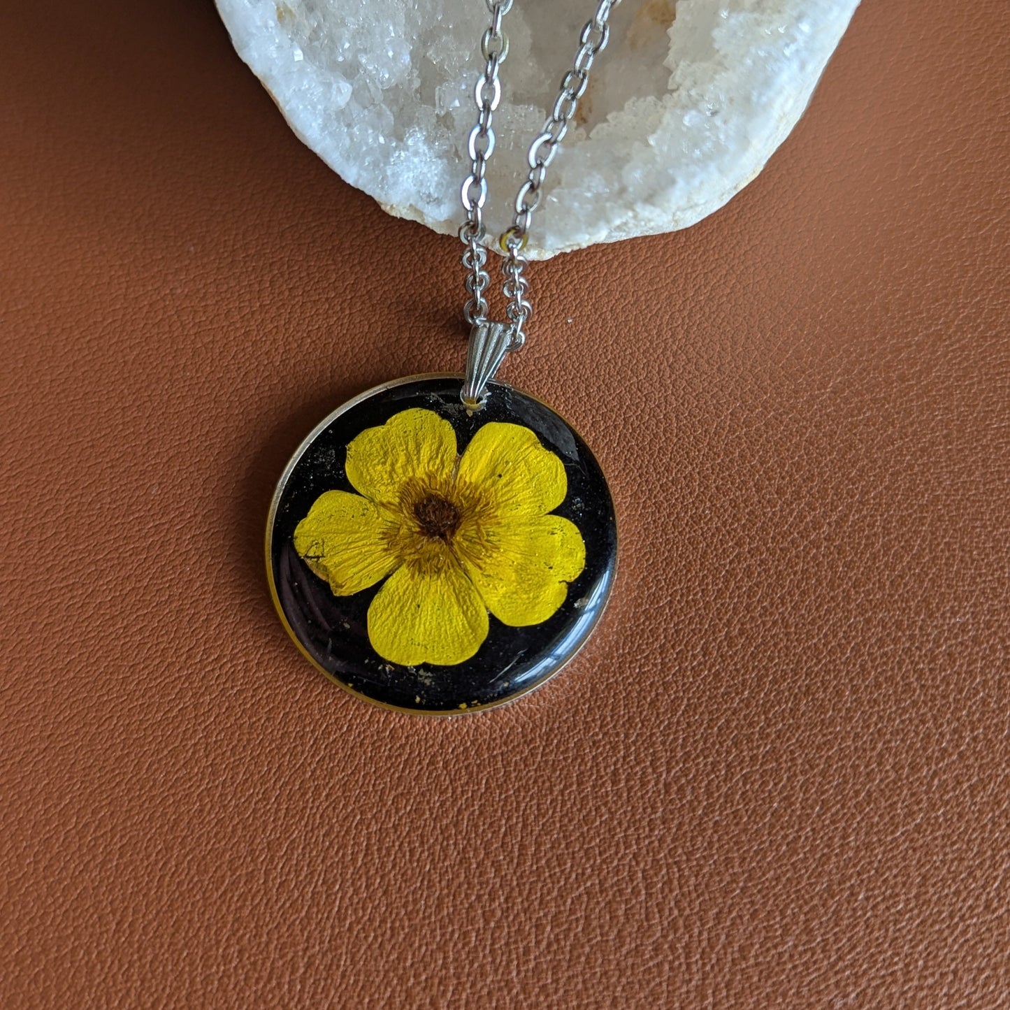 collier argenté avec bouton d'or jaune vif fleur séchée naturelle sur fond noir