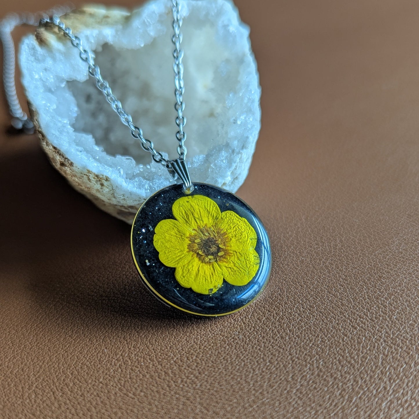 collier bouton d'or jaune sur fond noir et paillettes argentées