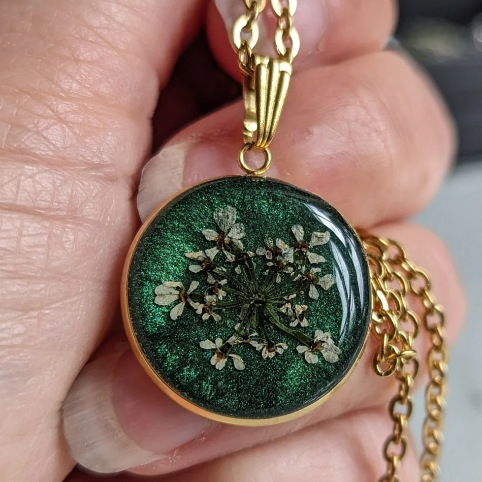 médaillon vert avec fleurs séchées blanches