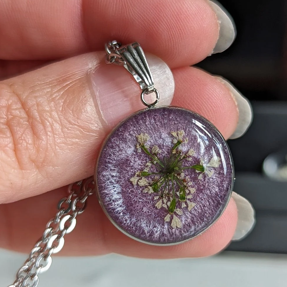 médaillon violet avec fleurs séchées blanches