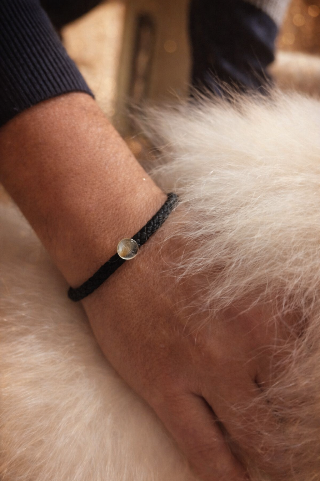 Bracelet souvenir Memorys pour homme porté au poignet, cuir noir tressé et résine personnalisée, création Étreinte Éternelle.