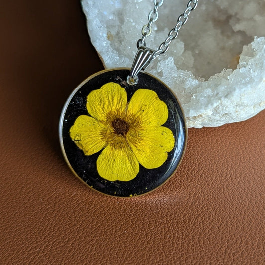 collier argenté avec bouton d'or jaune vif fleur séchée naturelle sur fond noir
