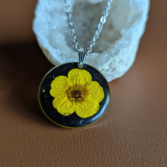 collier bouton d'or jaune sur fond noir et paillettes argentées