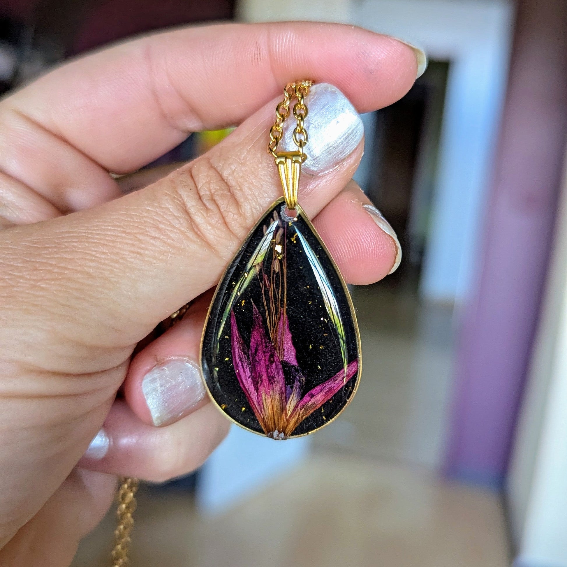 collier fleur fushia fond noir goutte dorée