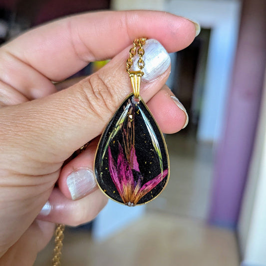 collier fleur fushia fond noir goutte dorée