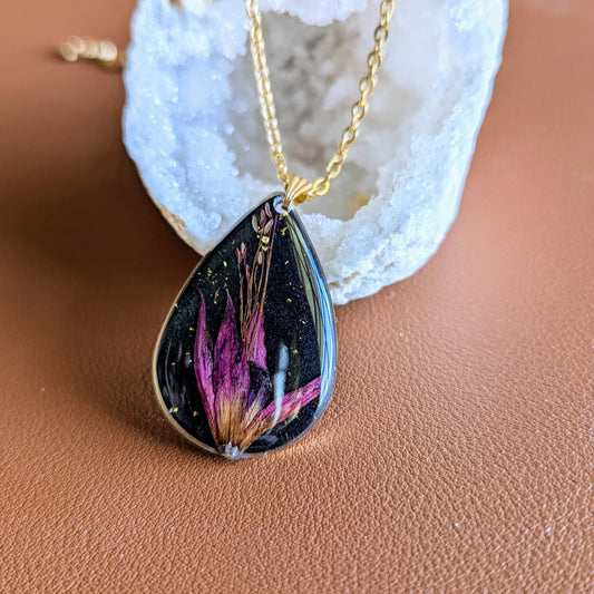 collier fleur fushia fond noir goutte dorée