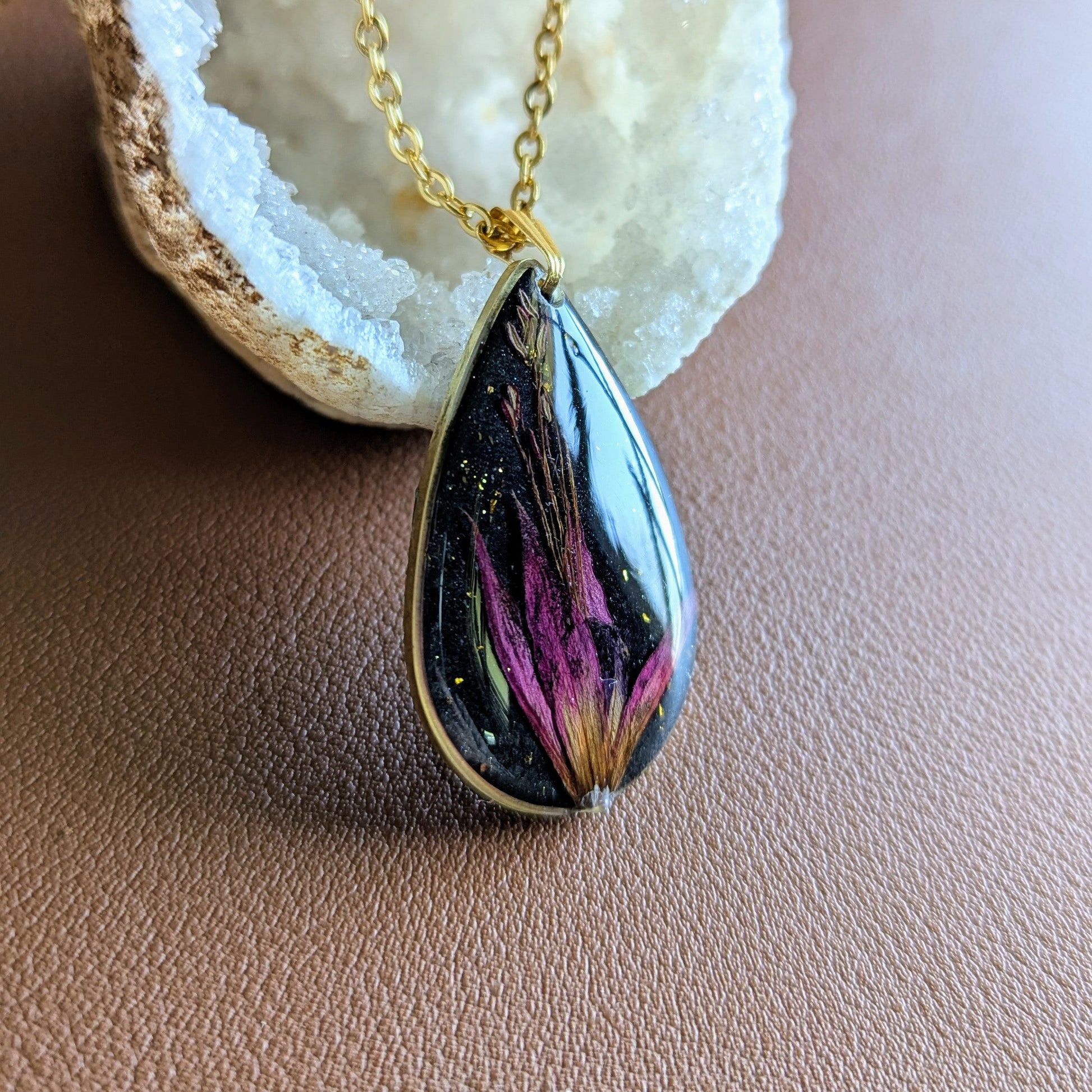 collier fleur fushia fond noir goutte dorée