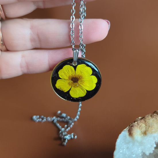 collier argenté avec bouton d'or jaune vif fleur séchée naturelle sur fond noir