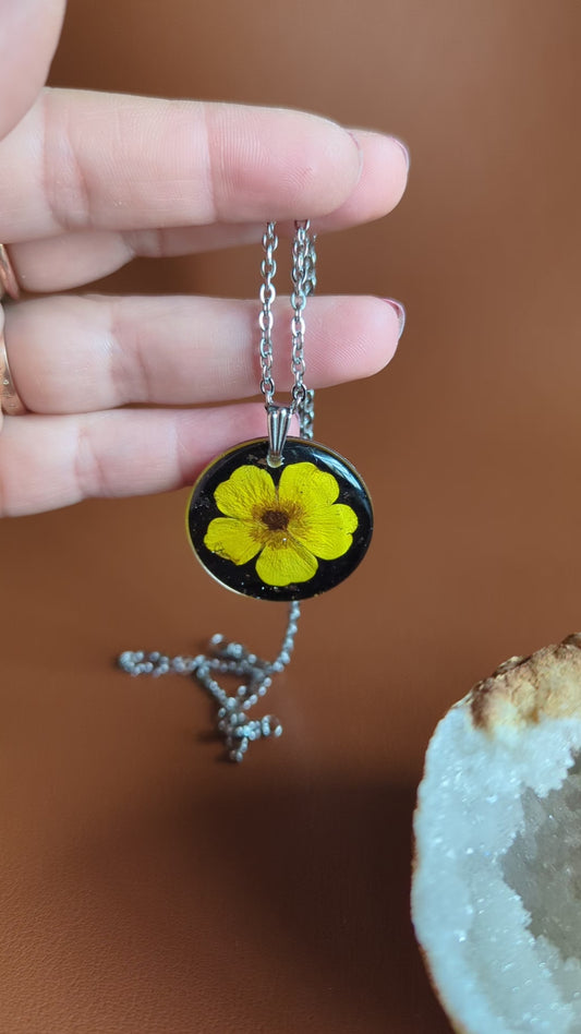 collier argenté avec bouton d'or jaune vif fleur séchée naturelle sur fond noir