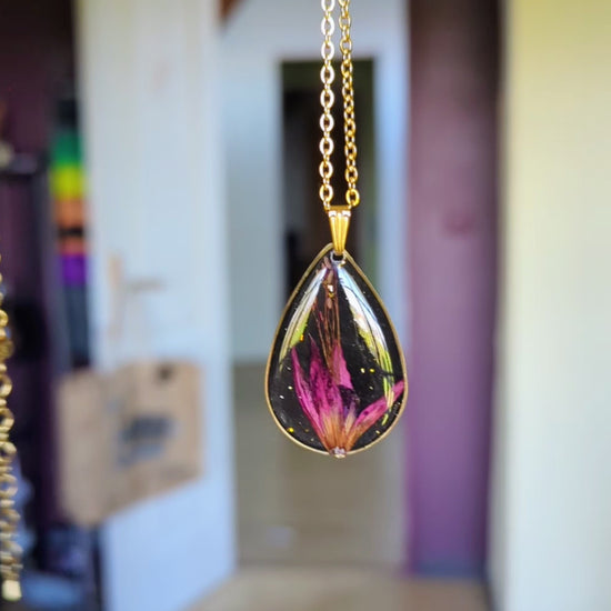 collier fleur fushia fond noir goutte dorée