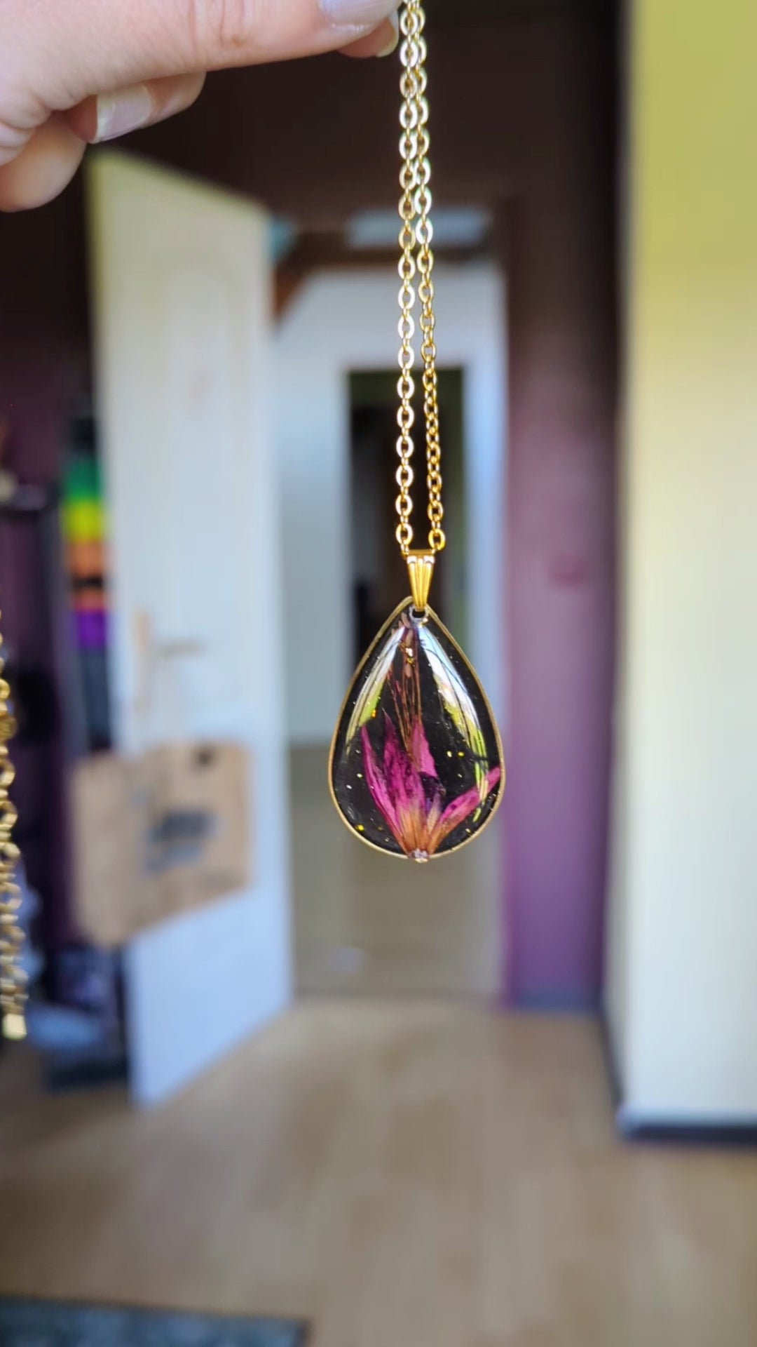 collier fleur fushia fond noir goutte dorée